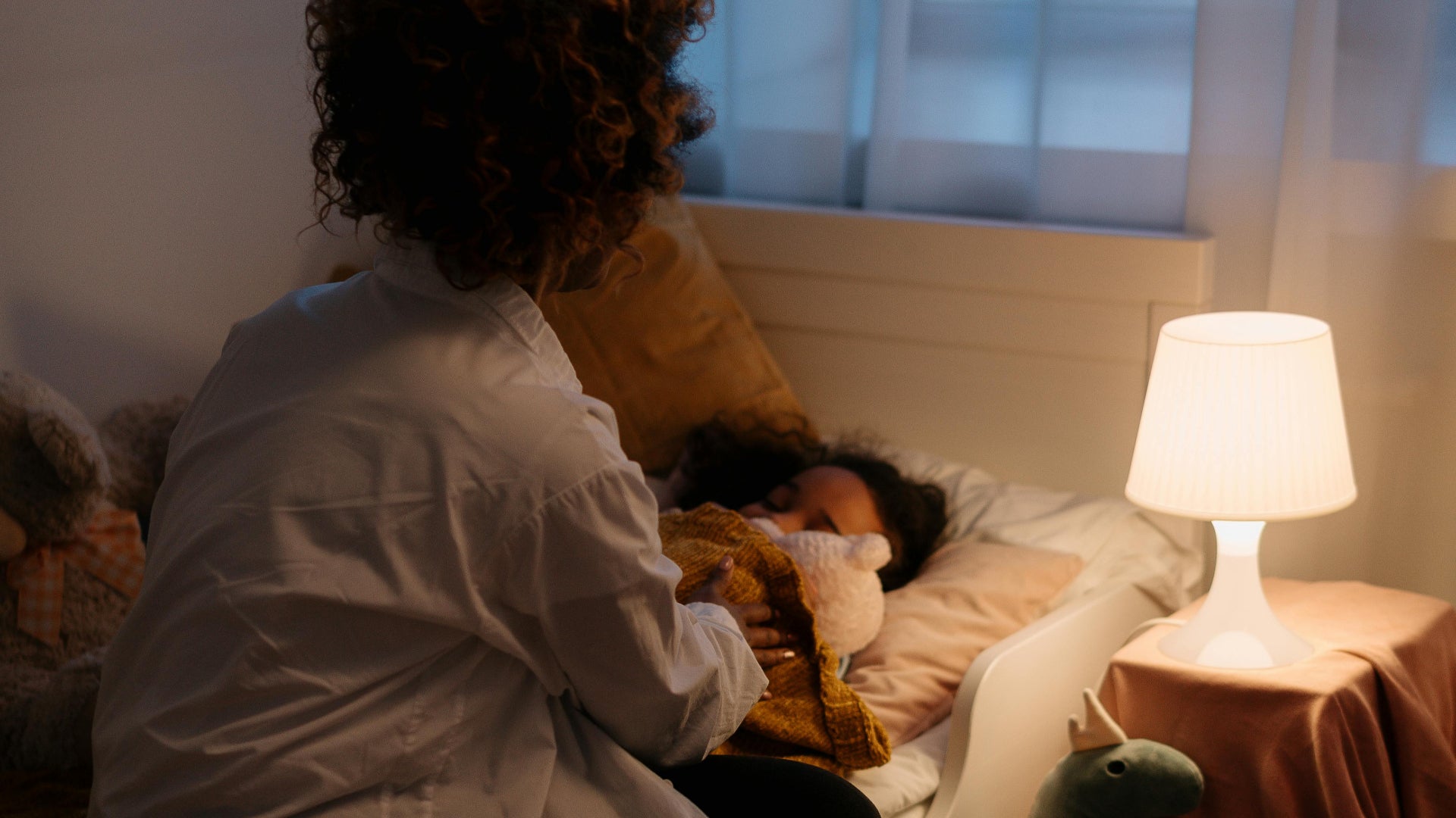 mother tucking in child humidified bedroom